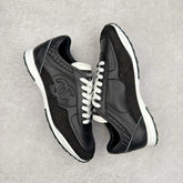 Chanel sneakers in black leather and suede with white laces.