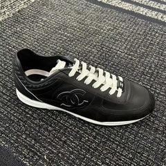 Chanel sneakers in black leather and suede with white laces.