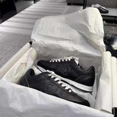 Chanel sneakers in black leather and suede with white laces.