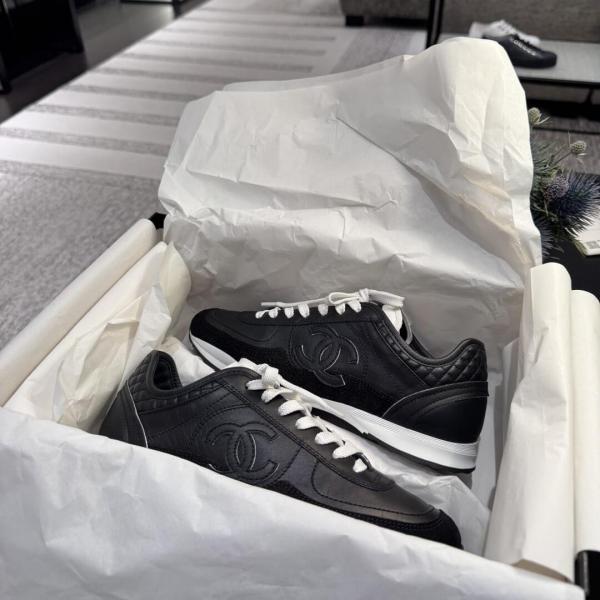 Chanel sneakers in black leather and suede with white laces.